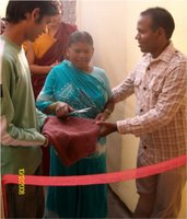 Shashi's mum cutting the ribbon to open the new school, Shashi on the right